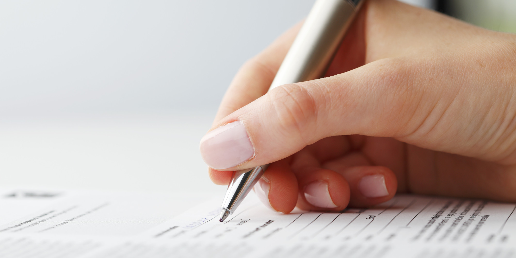 Main écrivant sur un document